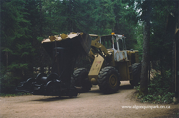 Image: Heavy machinery brings the donkey engine to its new home down the trail at the Algonquin Logging Museum, 1998. APPAC, 2020.18.2.119, J. Mihell. 