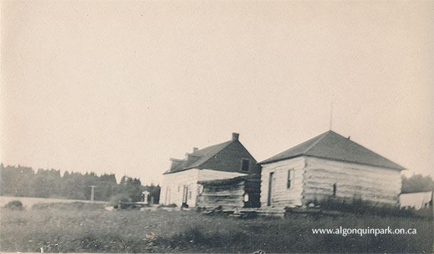Repurposed buildings from the Hawkesbury Lumber Company depot used by Algonquin Park staff at Brent, Cedar Lake, c. 1917-1920. The Rangers were likely sitting on the steps of the far building which was used as living quarters. APPAC, 2021.18.20. Estate of Janet Ivel (Hughes) Gurr.