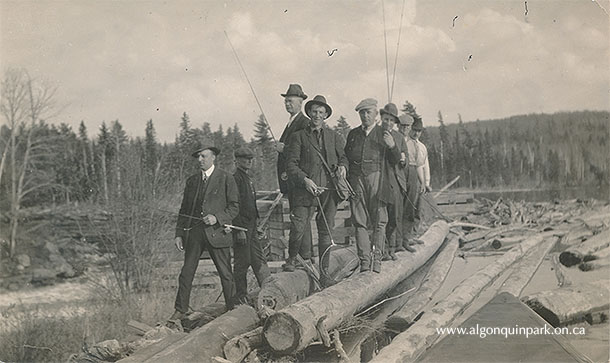 William Hughes, Park Ranger 1910-1920, stands holding a net in the middle of a group of fishermen. Brent, Cedar Lake, c. 1917 – 1920. APPAC, 2020.20.22. Estate of Janet Ivel (Hughes) Gurr. 