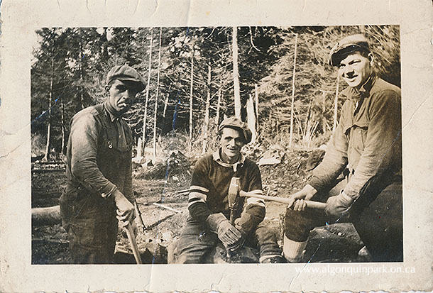 Image: Three Highway 60 construction workers posing with rock drilling tools, c. 1934 – 1936. The man in the middle holds a metal drill while Norman W. Gurr hits it with a sledgehammer. The holes would be filled with charges for blasting with dynamite. APPAC, 2021.18.37. Estate of Janet Ivel (Hughes) Gurr.