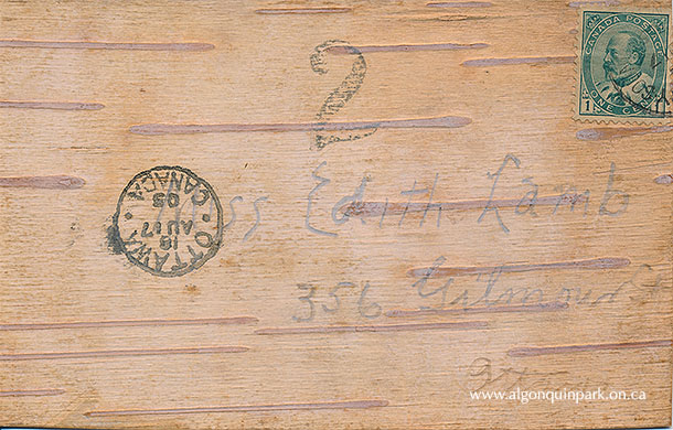 Birch bark postcard and reverse with stamp and postmark. “On the Trail”, 14 cm x 8.8 cm, birch bark and ink. APPAC, 2021.8.1. 